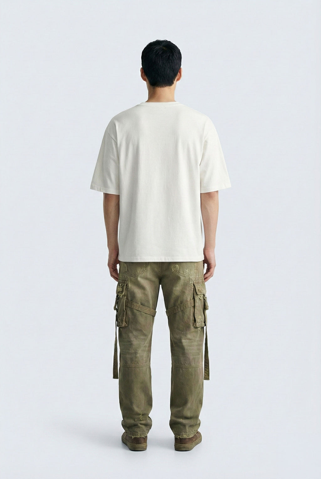 Person wearing a white t-shirt and green cargo pants on a white background