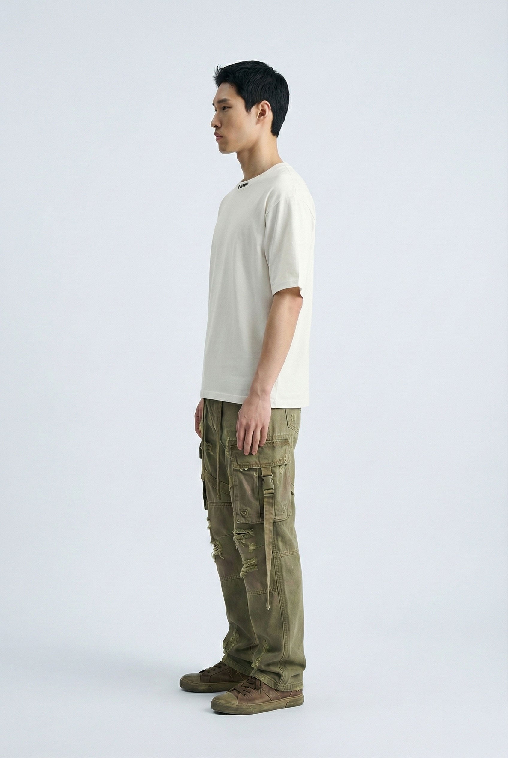 Person wearing a white t-shirt and green cargo pants on a white background