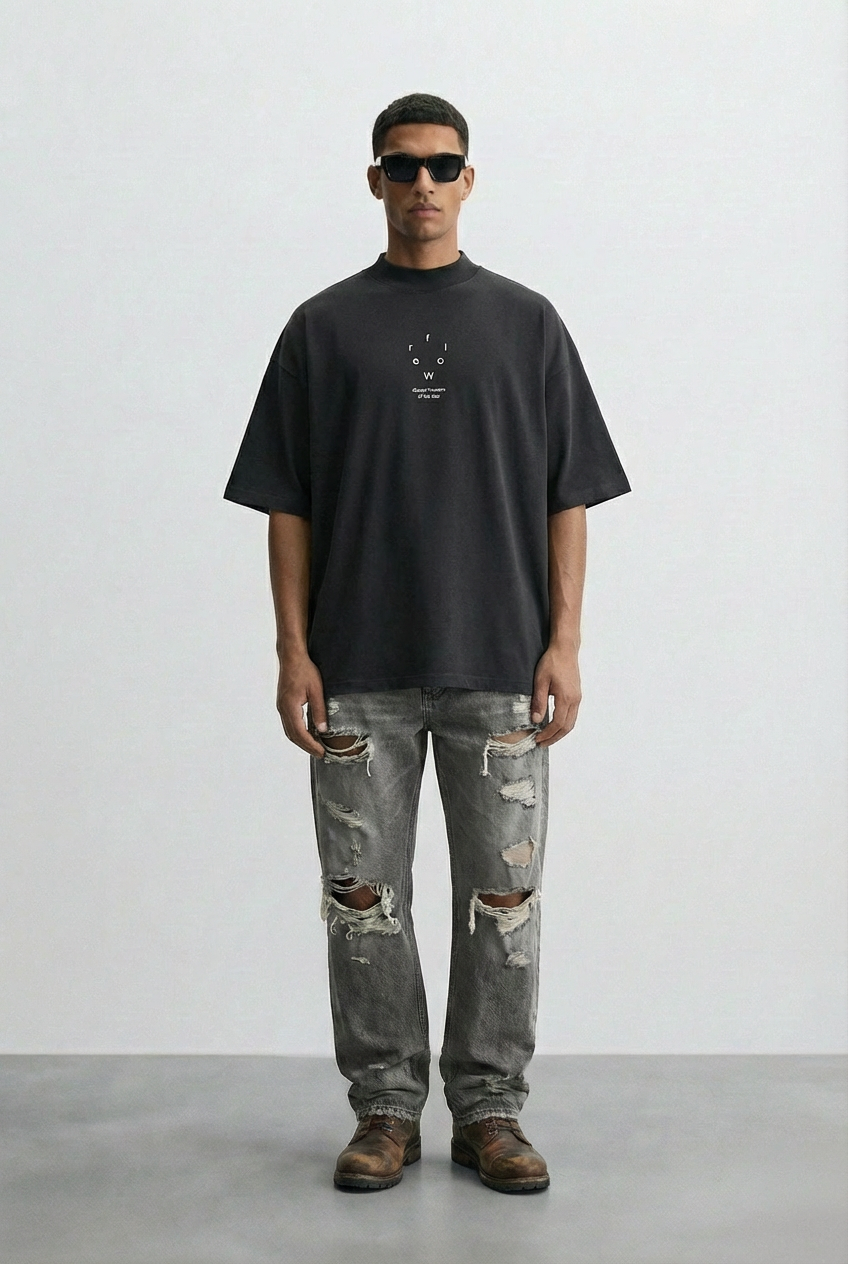 Person wearing a black t-shirt and ripped jeans against a white background